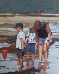 Woman and two children fishing in a rock pool